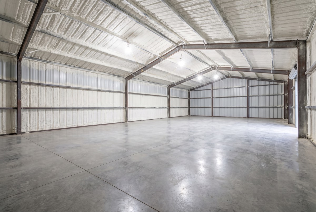 Metal barndominium shell interior fully insulated with white spray foam near Anna, TX